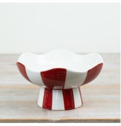 Crafted from ceramic with a high-gloss finish, the piece is elevated on a coordinating pedestal base