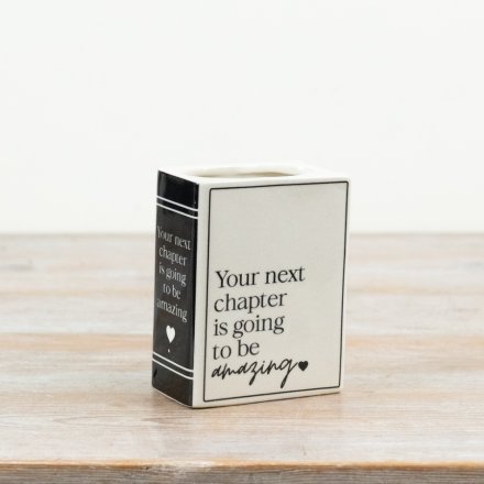 This ceramic book-style vase features a clean monochrome finish and the uplifting message “Your next chapter is going to