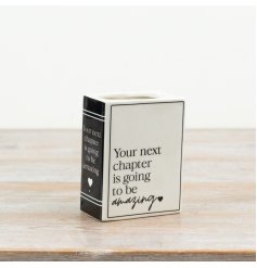 This ceramic book-style vase features a clean monochrome finish and the uplifting message “Your next chapter is going to