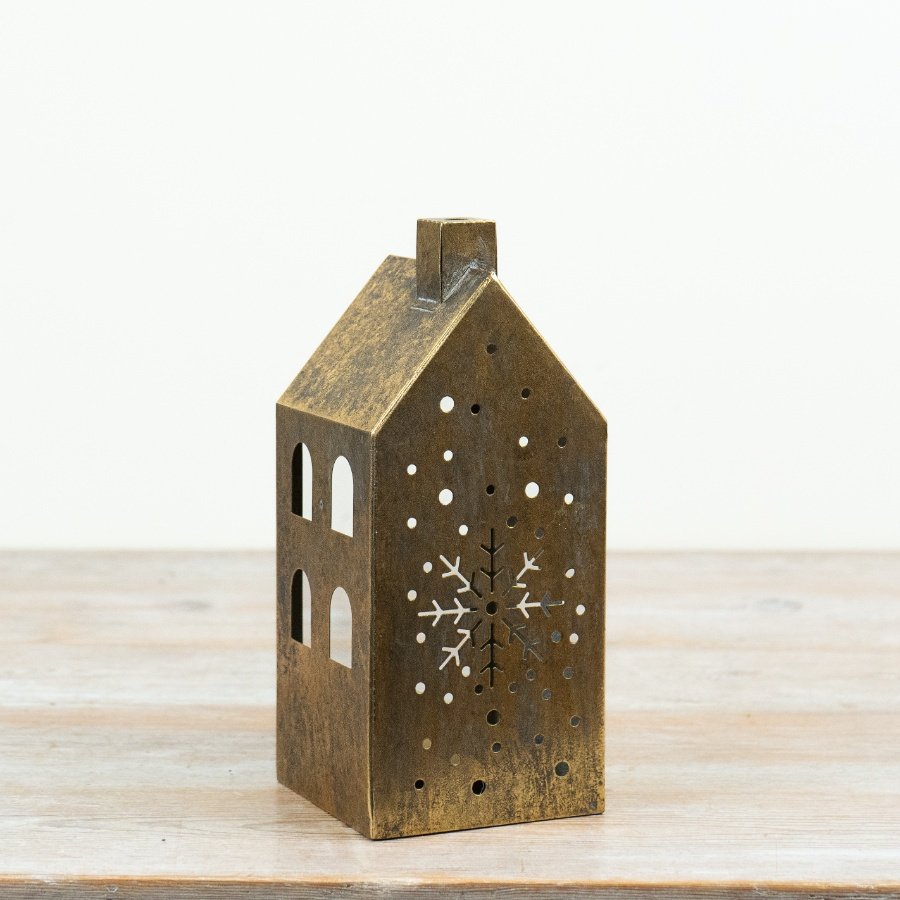 Add a warm, atmospheric glow to festive interiors with this antique gold house candle holder