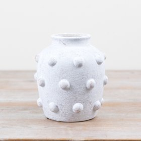 Charming white cement vase featuring a textured bobble pattern on its exterior.