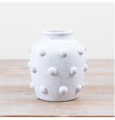 Charming white cement vase featuring a textured bobble pattern on its exterior.