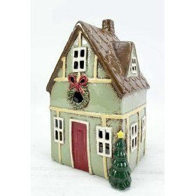 A delightful green shabby chic candle holder shaped like a cozy little house.