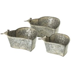 Add a charming touch to any space with this set of three elegant metal heart-shaped planters
