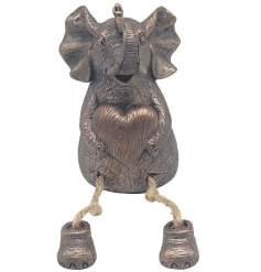 Adorable bronze Elephant named Tuskers sitting proudly while holding a heart.