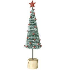 Delight in the charm of this festive tree with red berries and shining star topper