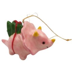 Charming pink dinosaur ornament carrying a gift, perfect for festive tree decor
