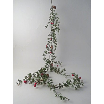 Rich green garland decorated with natural pinecones and bright red berries for enduring festive style