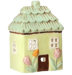 Bring cozy charm to your space with this pastel pink ceramic floral house tealight holder.