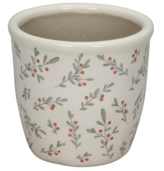 Traditional white ceramic planter with a festive touch of red berries and green branches