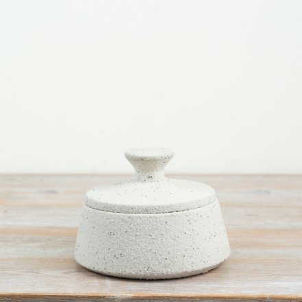 a sleek white storage jar with a matching lid to keep your small items neatly tucked away