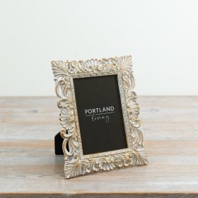 a vintage-inspired frame featuring an ornate design and a beautifully distressed finish