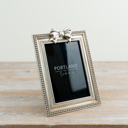 Delight in showcasing your cherished memories with this stylish bow-adorned photo frame