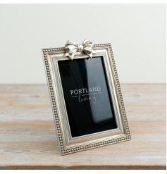 Delight in showcasing your cherished memories with this stylish bow-adorned photo frame