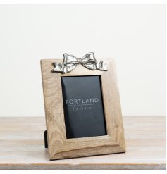 a rustic wooden picture frame with a elegant bow at the top 
