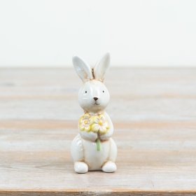 an adorable upright ceramic rabbit holding a colourful bouquet of flowers
