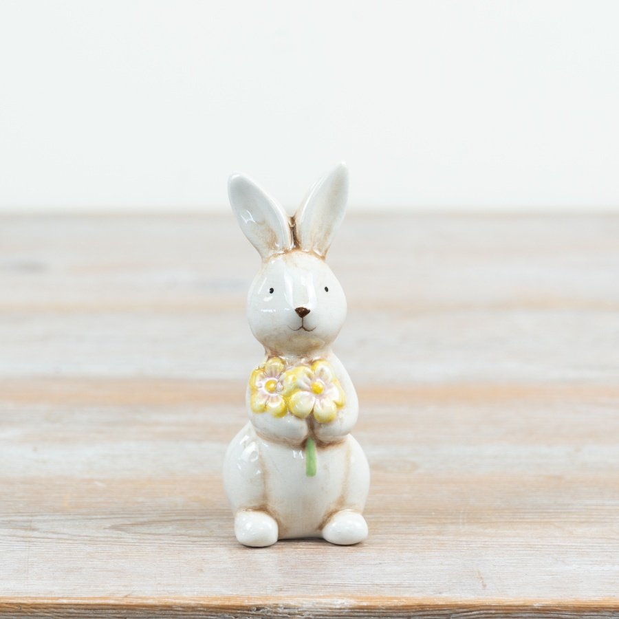an adorable upright ceramic rabbit holding a colourful bouquet of flowers