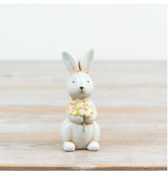 a charming standing glazed bunny rabbit holding a flowers 