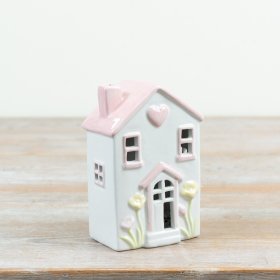 Bring a cosy glow to your home with this charming pastel-toned ceramic cottage