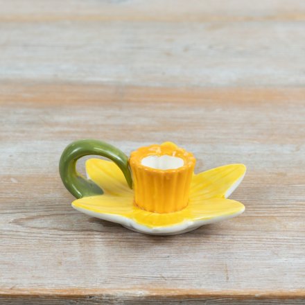 a charming candle holder modeled after a spring daffodil with layered yellow petals and a contrasting trumpet cup.