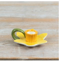 a charming candle holder modeled after a spring daffodil with layered yellow petals and a contrasting trumpet cup.