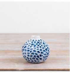 Add a fresh seaside charm with this round, ceramic bud vase featuring a delicate dimpled pattern