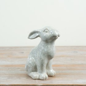 Featuring a realistic seated pose and expressive eyes for a charming decorative focal point