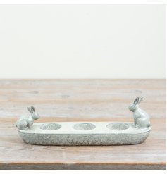An adorable bunny-themed candle holder with three round slots