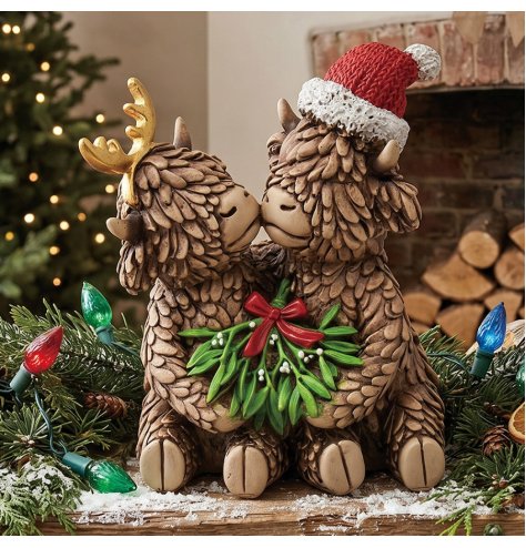 an endearing resin ornament featuring a darling pair of highland cows