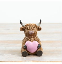 adorable seated Highland cow clutching a delicate pink heart
