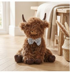 Endearing Highland cow doorstop adorned with a quaint bow for a homely country vibe