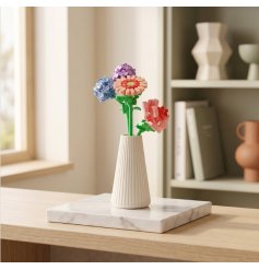 charming pink, baby blue, and lavender flowers nestled in a stylish ribbed white vase