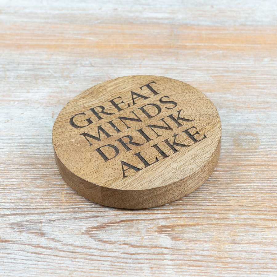 A playful round coaster engraved with a witty phrase to brighten any drink spot