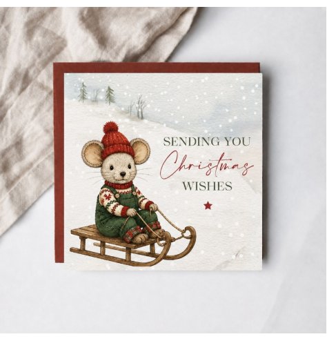 A festive card showing a little mouse relaxing on a sledge in a snowy scene