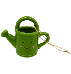 Charming green watering can decoration with friendly smile, perfect for hanging