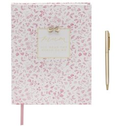 A beautiful hardcover journal with a soft pink floral design and matching gold pen