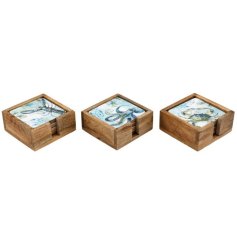 Four elegant coasters with marine enamel artwork presented in wooden trays