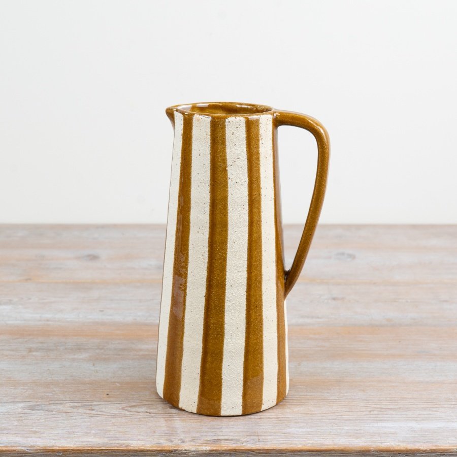 A tall mustard jug vase with distinctive stripes and rustic appeal